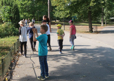 Lapset ovat eläintarhassa ja kävelevät kävelytiellä.