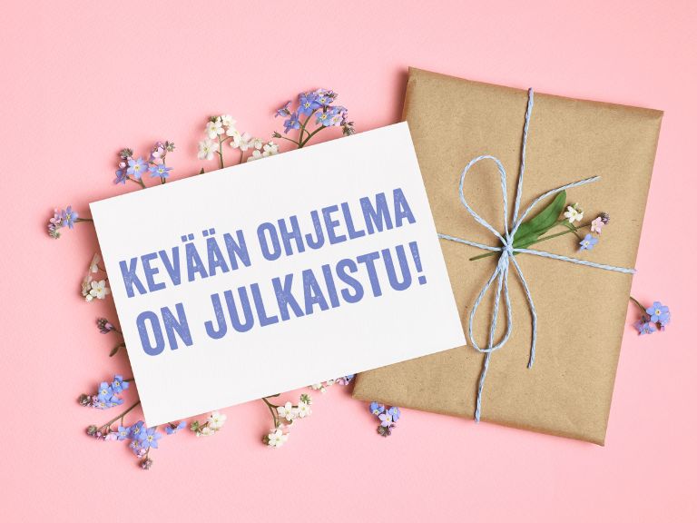 paketti ja kukkasia vaaleanpunaisella taustalla.